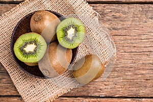 Kiwi fruit in a bowl on wooden background.