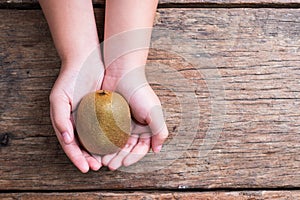 Kiwi fruit in a bowl on wooden background.