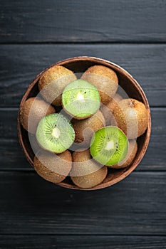 Kiwi fruit in a bowl on wooden dark table