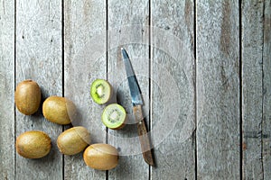 KIwi fruit and knife on wooden background.