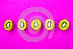 Kiwi fruit pattern on pink colored background, minimal flat lay style, copy space.