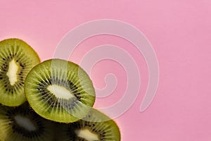Kiwi fruit Slices macro. Ripe Kiwi fruit isolated on pink background. pace for text, blank. Layout. Background for text