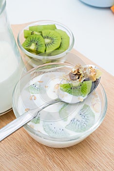 Kiwi in a glass bowl with cereal, on the table