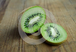Kiwi, greencolor, fruit on brown wooden background.