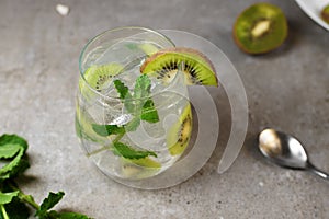 Kiwi mojito cocktail or caipirinha drink recipes with mint and ice in glasses close up. Summer cold drink kiwi lemonade