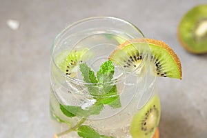 Kiwi mojito cocktail or caipirinha drink recipes with mint and ice in glasses close up. Summer cold drink kiwi lemonade