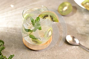 Kiwi mojito cocktail or caipirinha drink recipes with mint and ice in glasses close up. Summer cold drink kiwi lemonade