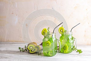 Kiwi Mojito cocktail or non-alcohol mocktail with mint and sliced kiwi fruits on wooden background copy space