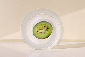 Kiwi in round ice. Concept of shock freezing of fruits and frozen food. Preservation of summer vitamins. Juicy light green color.