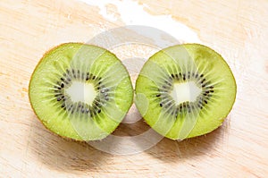 Kiwi sliced 2 segments on chopping block