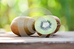 kiwi slices close up and fresh whole kiwi fruit wooden and nature green background