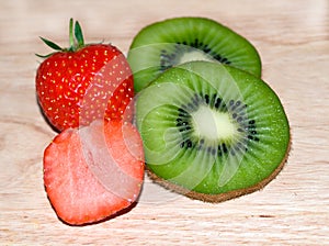 Kiwi slices strawberry slices on a broad. 