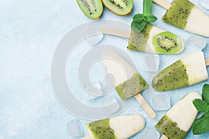 Kiwi smoothie and yogurt fruity popsicles or homemade ice cream top view. Summer refreshing food.