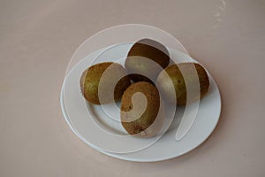 Kiwi on a white plate. Still life.