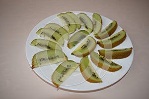 Kiwi on a white plate. Still life.