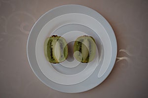 Kiwi on a white plate. Still life.