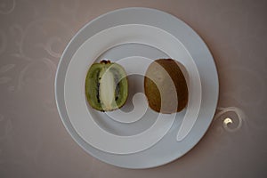 Kiwi on a white plate. Still life.