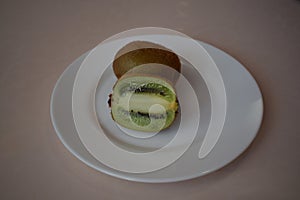 Kiwi on a white plate. Still life.