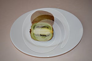 Kiwi on a white plate. Still life.