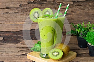 Kiwi yogurt smoothies juice,beverage healthy the taste yummy In glass drink episode morning on wood background.