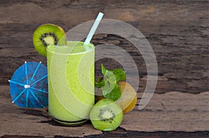 Kiwi yogurt smoothies juice,beverage healthy the taste yummy In glass drink episode morning on wood background.