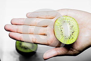 Kiwifruit Healthy eating and diet Topic Human hand holding a half kiwi isolated on a white background in the studio