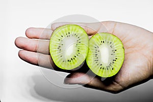 Kiwifruit Healthy eating and diet Topic Human hand holding a half kiwi isolated on a white background in the studio