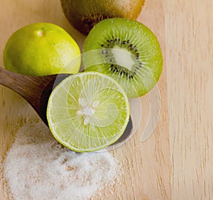 Kiwifruit and lemon with salt on wood cutting board