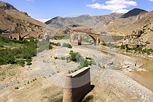 Kiz bridge destroy in Iran by the communist in Tabriz at the dokhtar river with mountains and a iranian guy walking