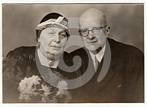 Vintage photo shows a married couple - silver wedding anniversary. Retro black and white studio photography.