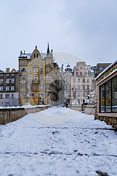 Small gothic bridge over Mlynowka river located at city center and covered by fresh snow at winter