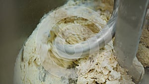 Kneading Dough. Baker preparing the dough for bread in a dough mixer. Manufacture of bakery products. The baker is