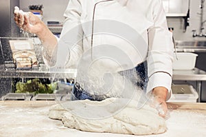 Kneading and preparation of sourdough-based bread. On a wooden table.