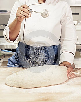 Kneading and preparation of sourdough-based bread. On a wooden table.