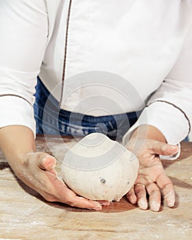 Kneading and preparation of sourdough-based bread. On a wooden table.