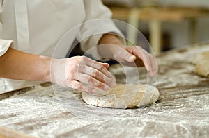 Kneading yeast-free raw dough in the hands of a baker
