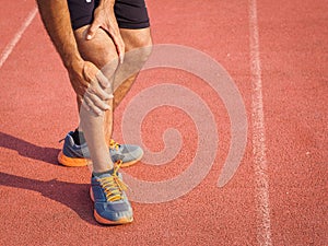 Knee Injuries. sport man with strong athletic legs holding knee