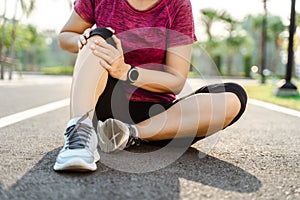 Knee Injuries. sport woman with strong athletic legs holding knee with her hands in pain after suffering muscle injury during a