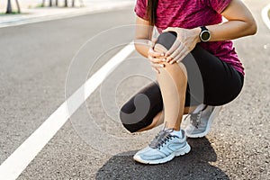 Knee Injuries. sport woman with strong athletic legs holding knee with her hands in pain after suffering muscle injury during a