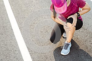 Knee Injuries. sport woman with strong athletic legs holding knee with her hands in pain after suffering muscle injury during a