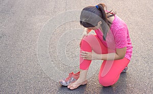 Knee Injuries. Young sport woman holding knee with her hands in pain after suffering muscle injury during a running workout at