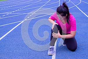 Knee Injuries. Young sport woman holding knee with her hands in pain after suffering muscle injury during a running workout on