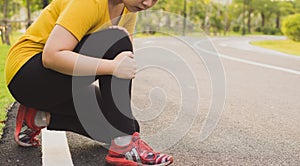 Knee Injuries. Young sport woman holding knee with her hands in pain after suffering muscle injury during a running workout at the