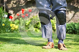 Knee pads worn by elderly senior old man in garden