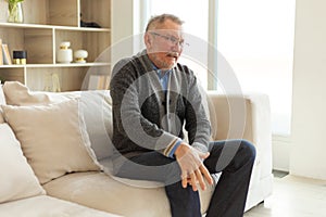 Knee pain arthritis body sick health care concept. Unhappy middle aged senior man suffering from knee ache sitting on