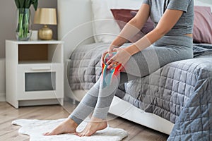 Knee pain, woman with osteoarthritis and legs ache, chiropractic treatments concept in home interior