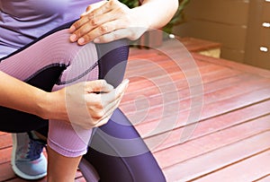 Knee pain. Young woman suffering knee injury while exercising and running. Healthcare and sport concept.