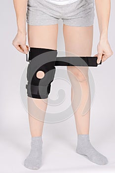 Knee Support Brace on leg isolated on white background. Elastic orthopedic orthosis. Anatomic braces for knee fixation