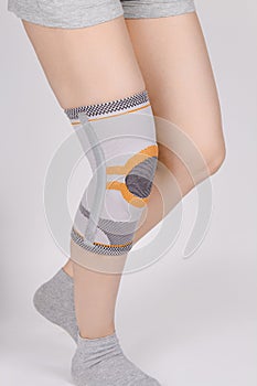 Knee Support Brace on leg isolated on white background. Elastic orthopedic orthosis. Anatomic braces for knee fixation