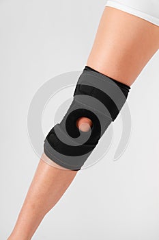 Knee Support Brace on leg isolated on white background. Elastic orthopedic orthosis. Anatomic braces for knee fixation